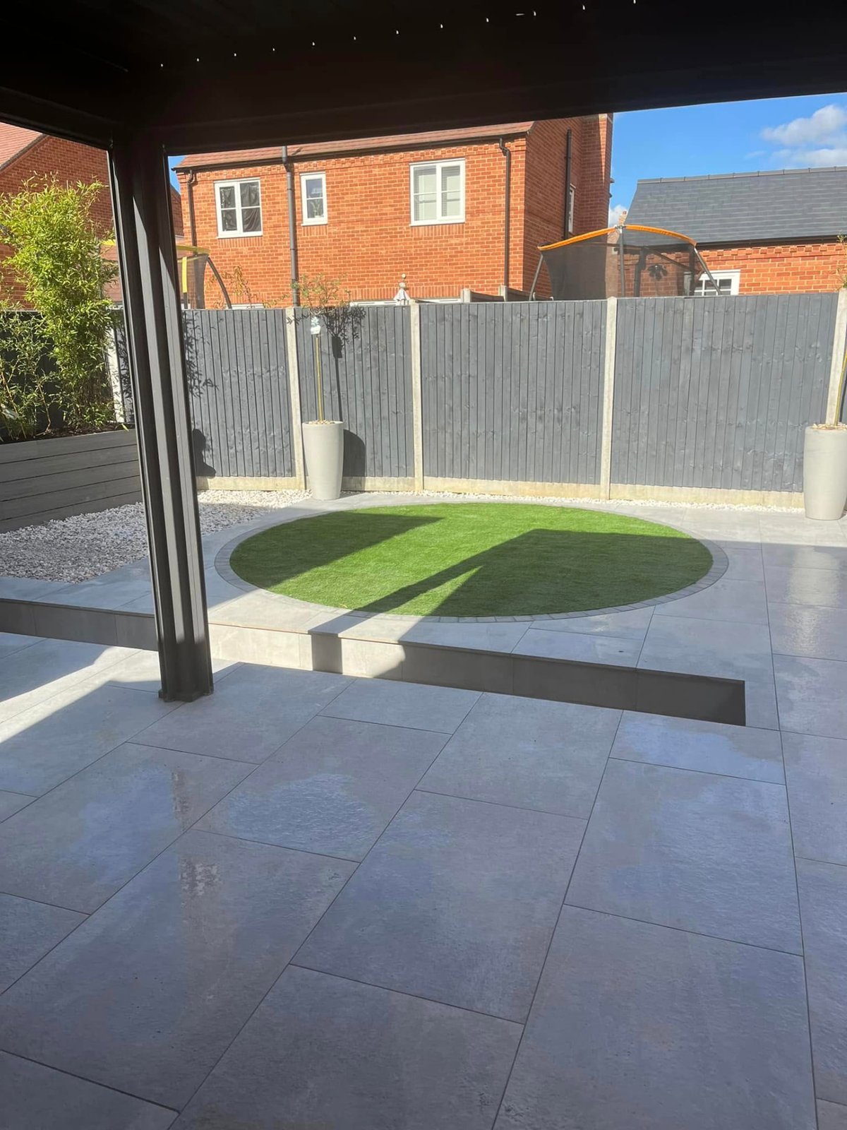 Completed rear garden landscaping with porcelain paving, curved lawn and new fencing