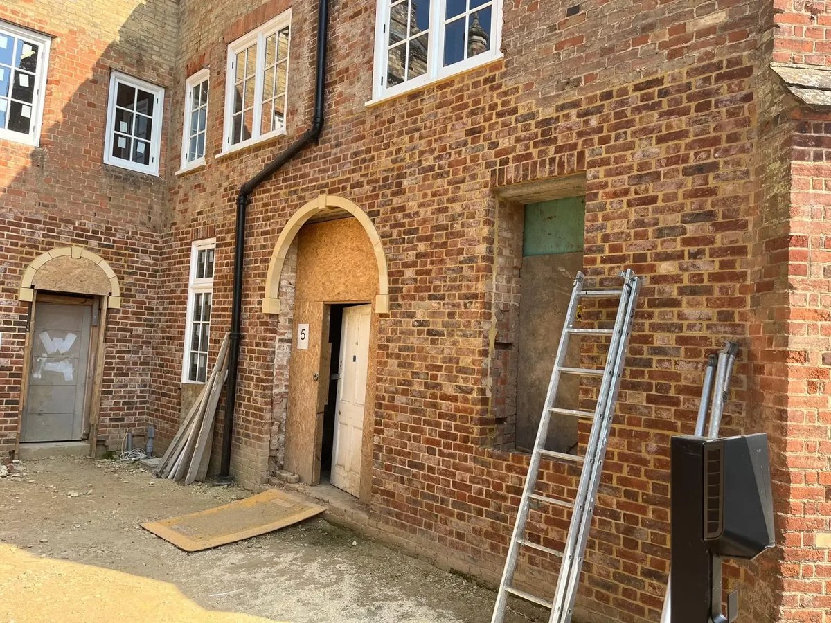 Restored heritage brick elevation with arched openings during building work