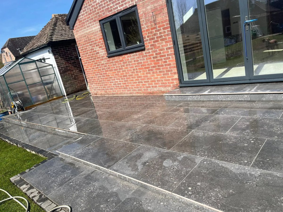 Large porcelain patio wrapping around the rear of the house, Wyton