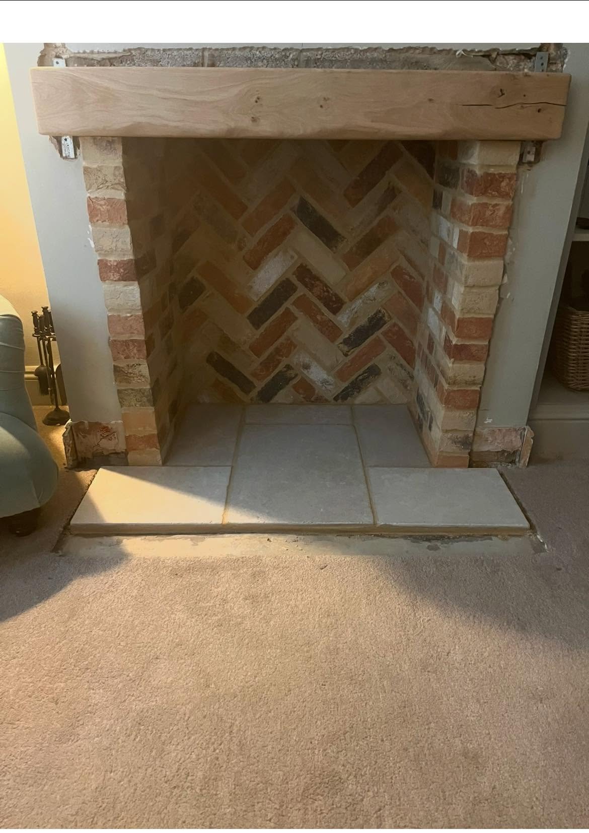 Bespoke reclaimed brick fireplace with oak beam and stone hearth built in Cambridgeshire
