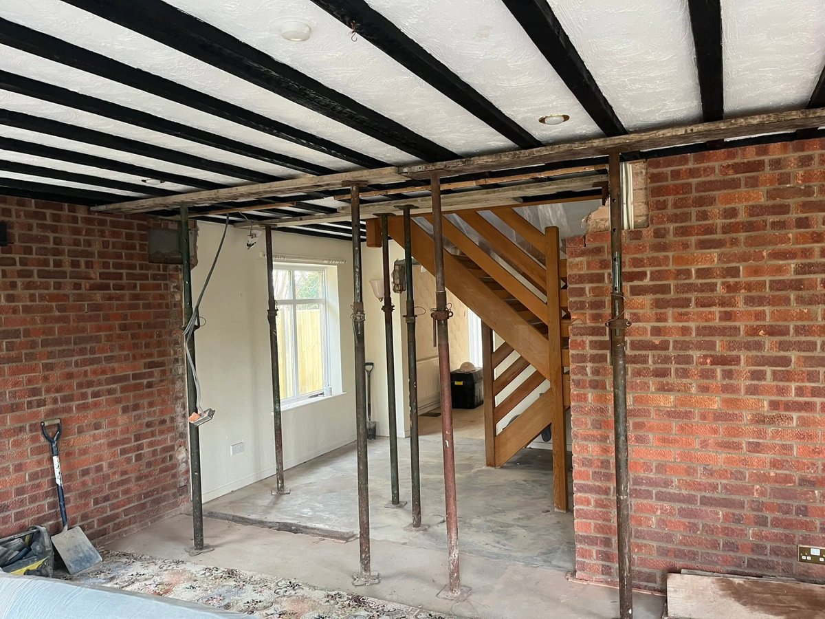 Load-bearing wall removal supported on acrow props and strongboys before a new structural beam is installed