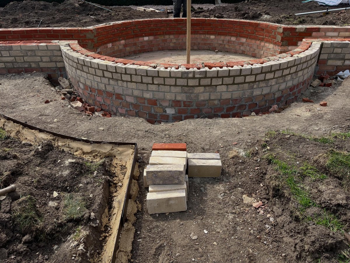 Circular brick basin under construction for a garden water feature