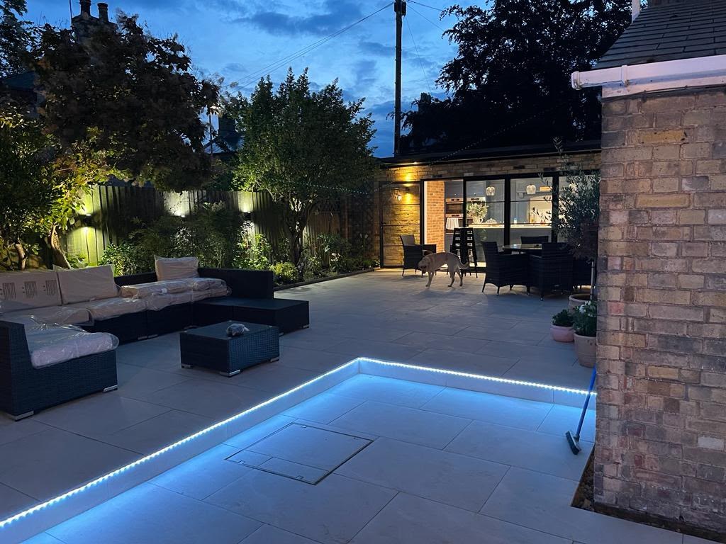 Patio and seating area lit with inset lighting at dusk, High Street Warboys