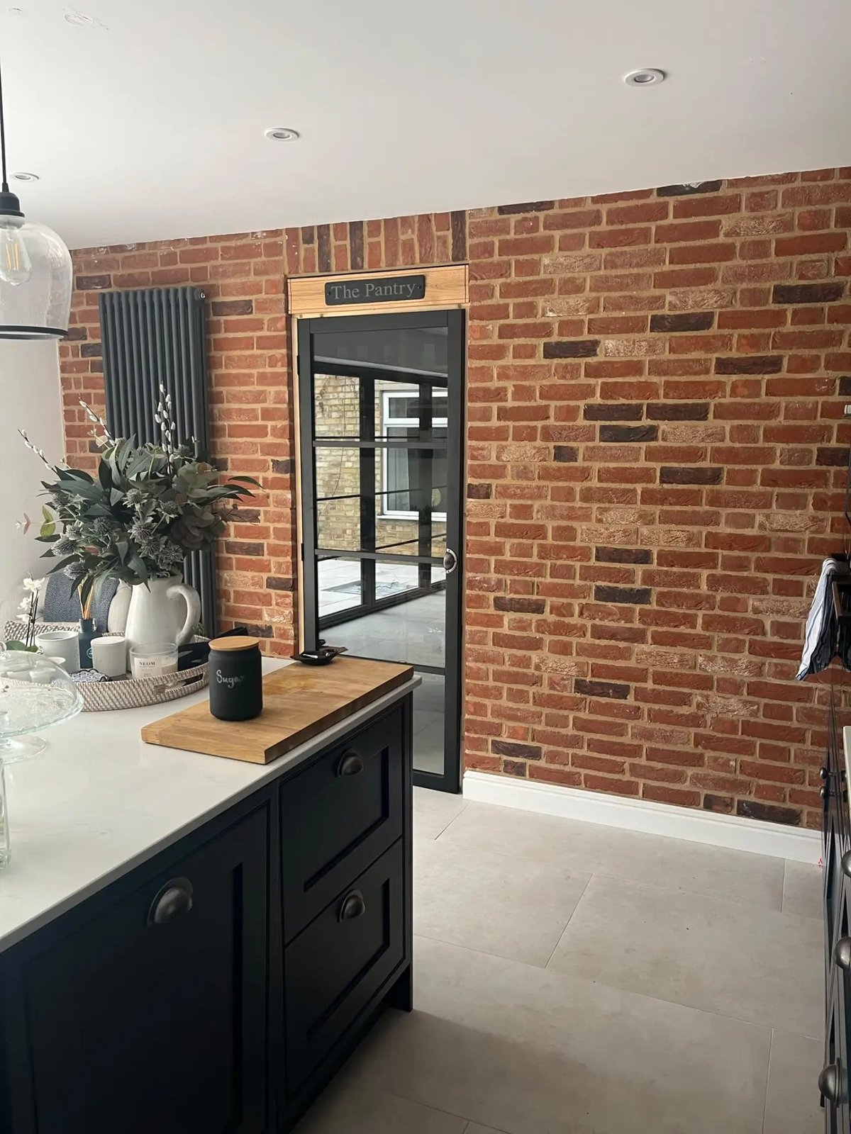 Glazed pantry door set into the brick feature wall of the new kitchen, High Street Warboys