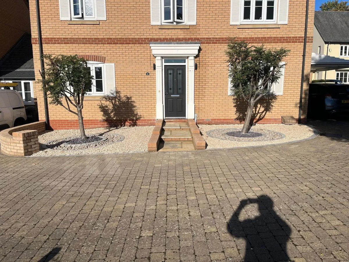 Completed low-maintenance front garden with gravel, curved brick edging and paved entrance path
