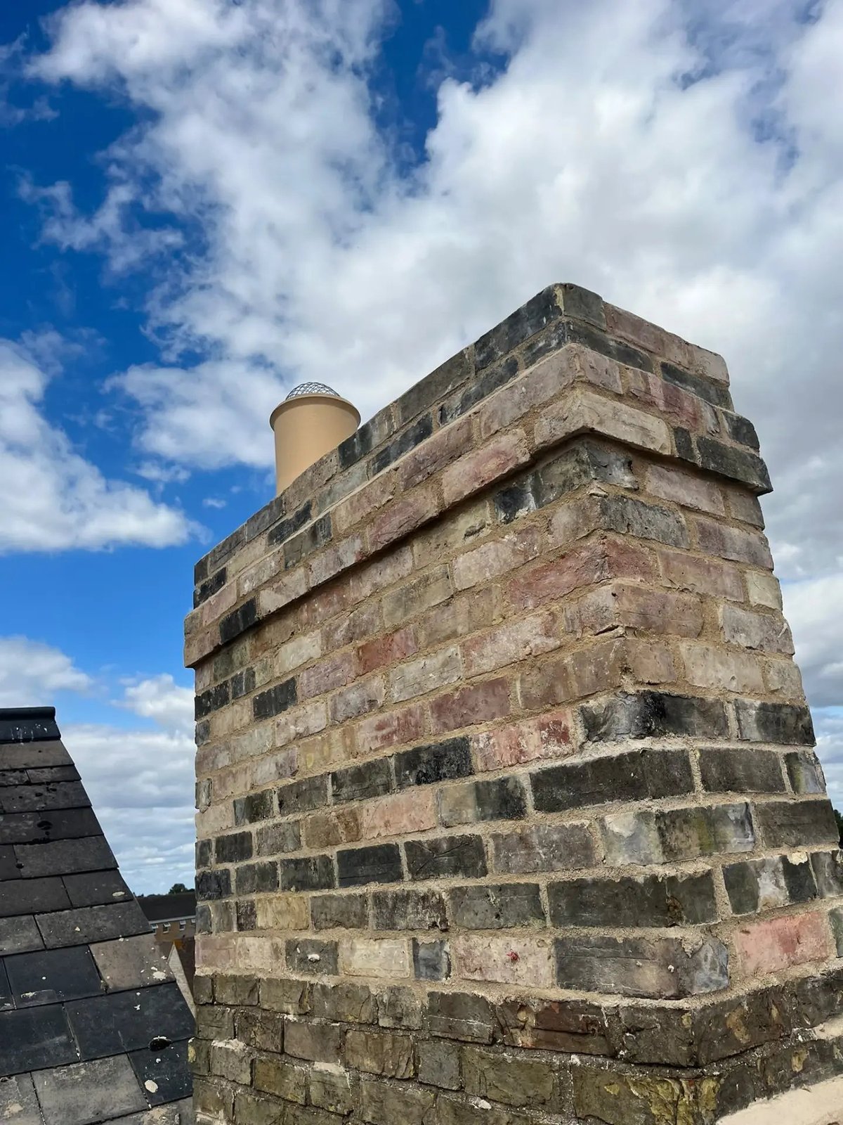 Rebuilt brick chimney stack with corbelled detailing and new flue pot, Willingham