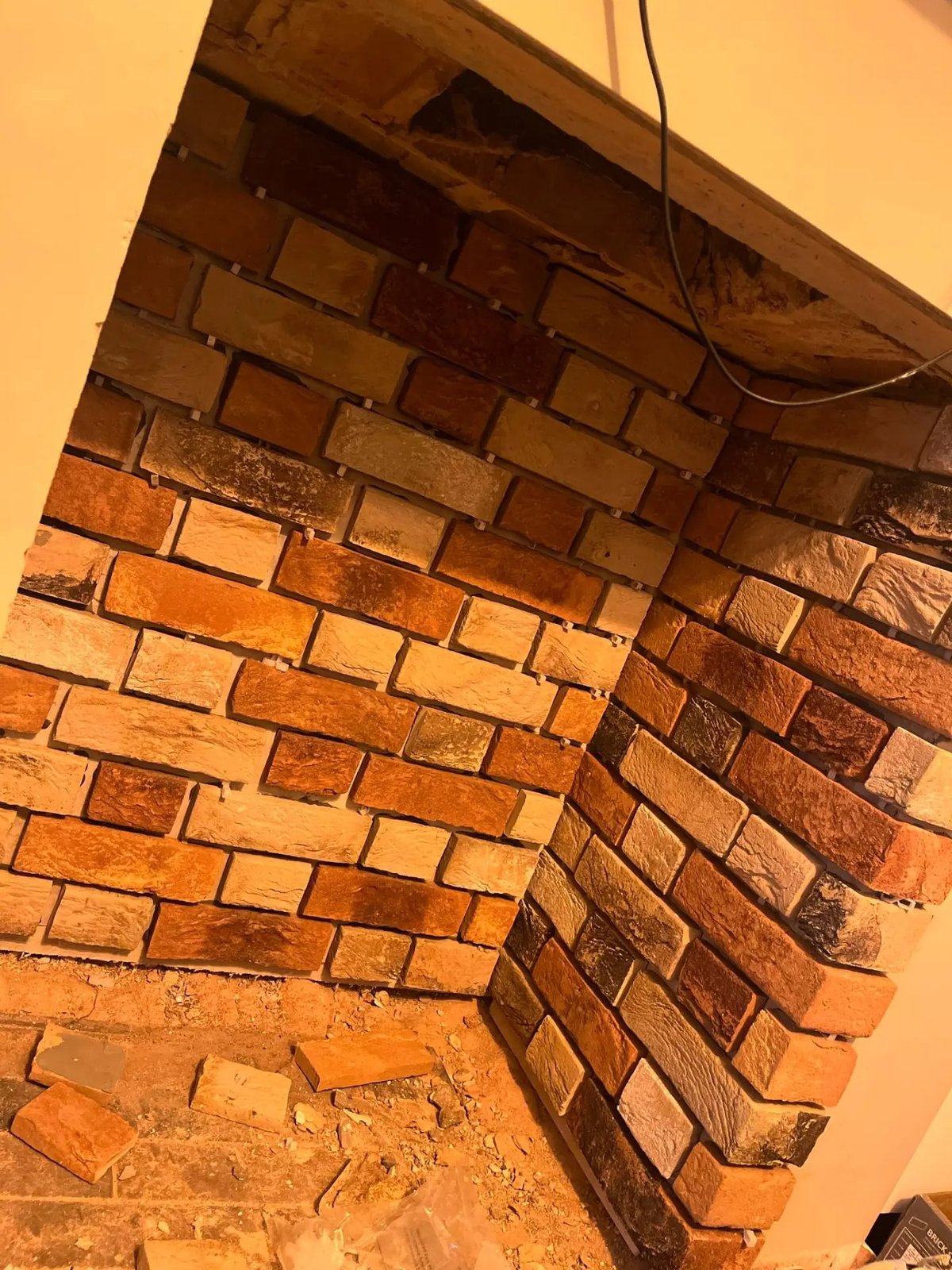 Reclaimed-look brick slips being fixed to the internal feature wall, High Street Warboys