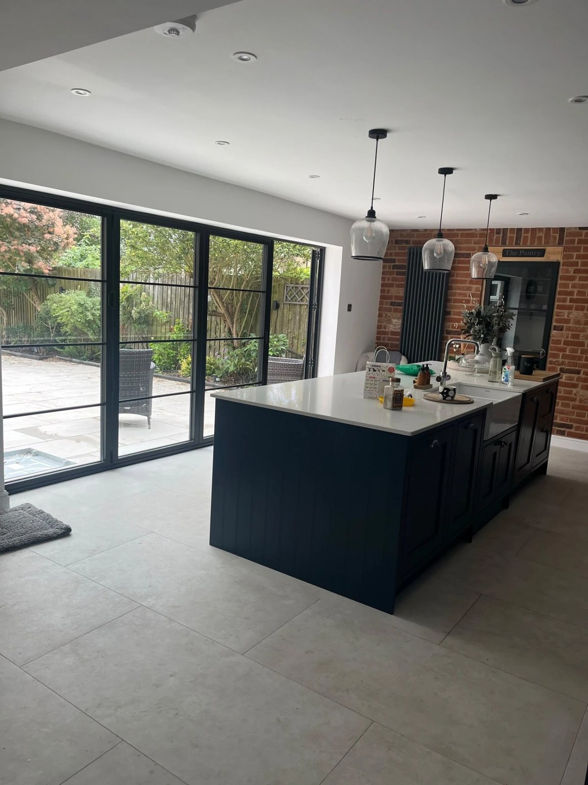 Open-plan kitchen with Crittall-style bifold doors onto the patio, High Street Warboys