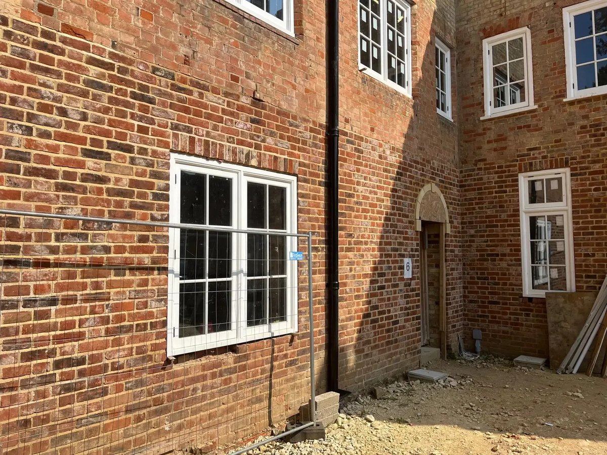 Restored red brick courtyard elevation with new windows and repointed masonry