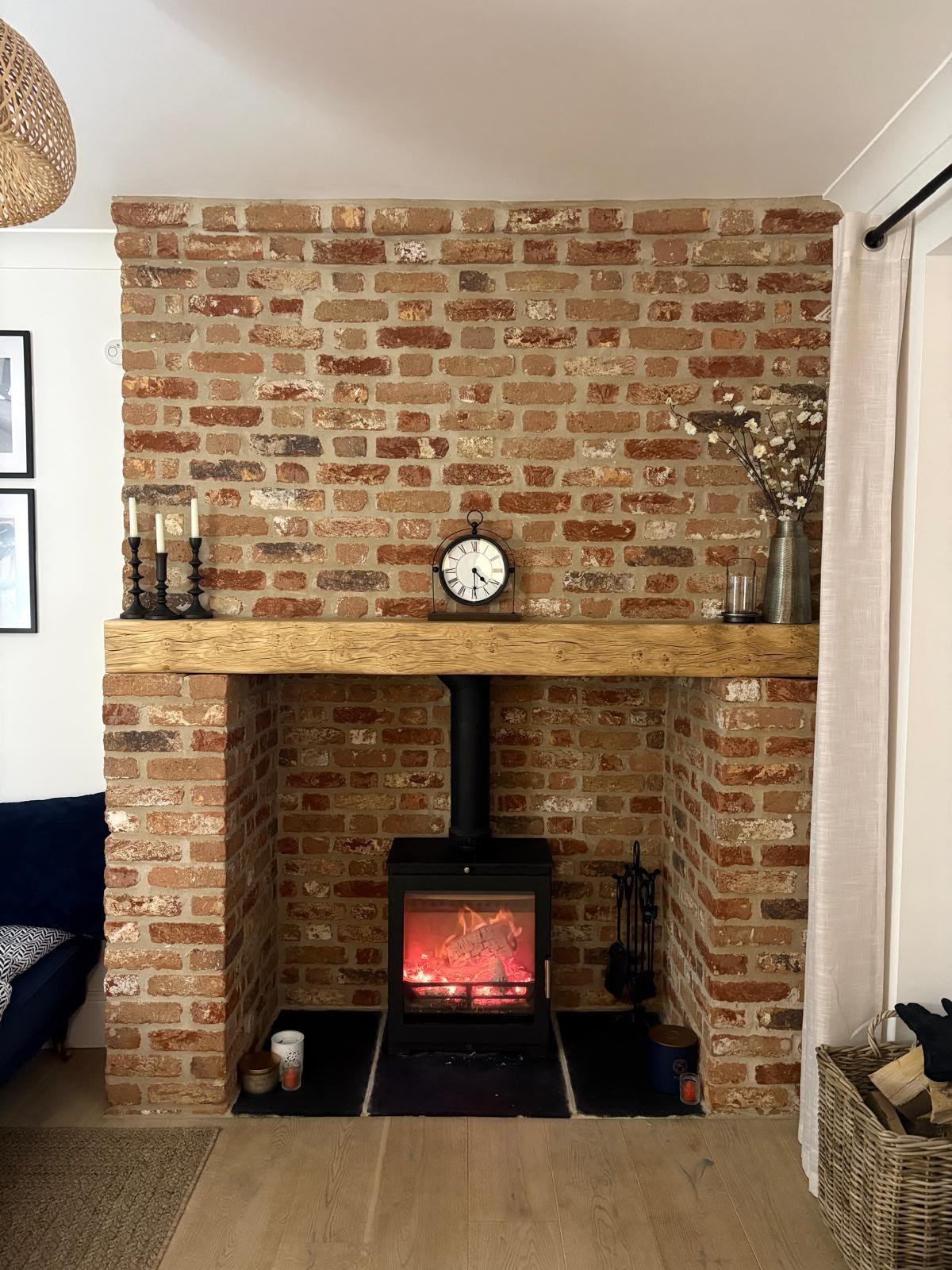 Brick fireplace chamber with oak beam mantel and log burner, High Street Warboys