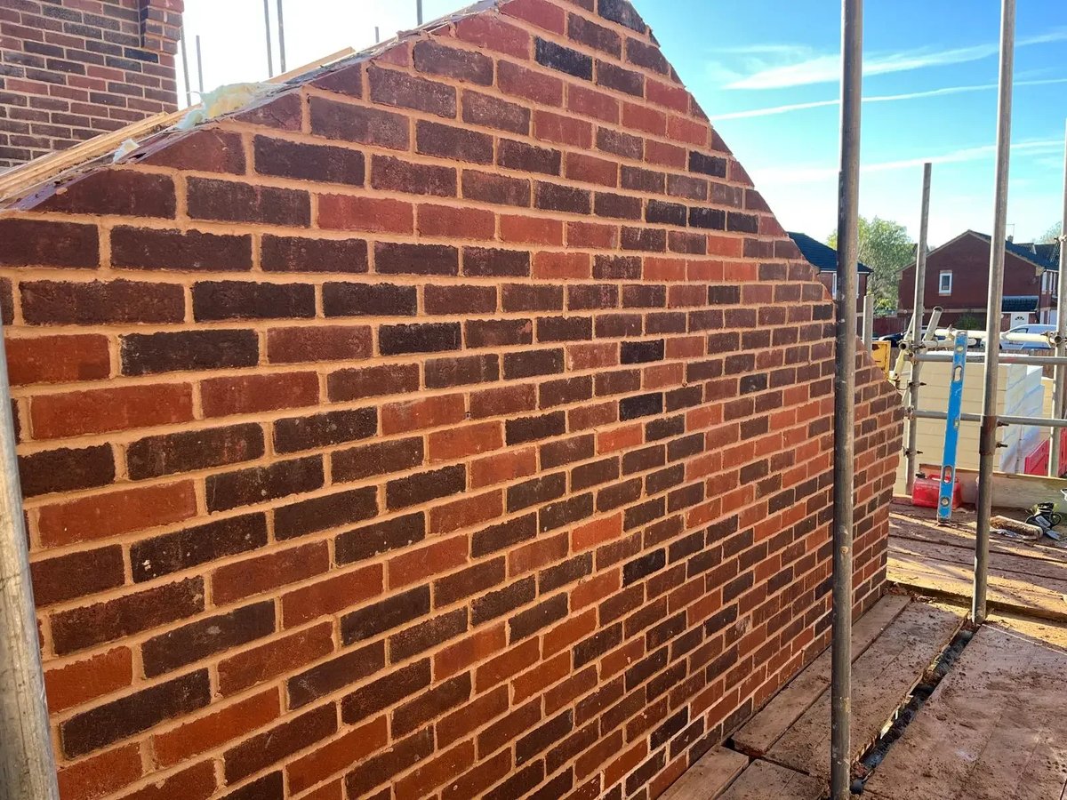New red brick gable wall under construction with scaffold access