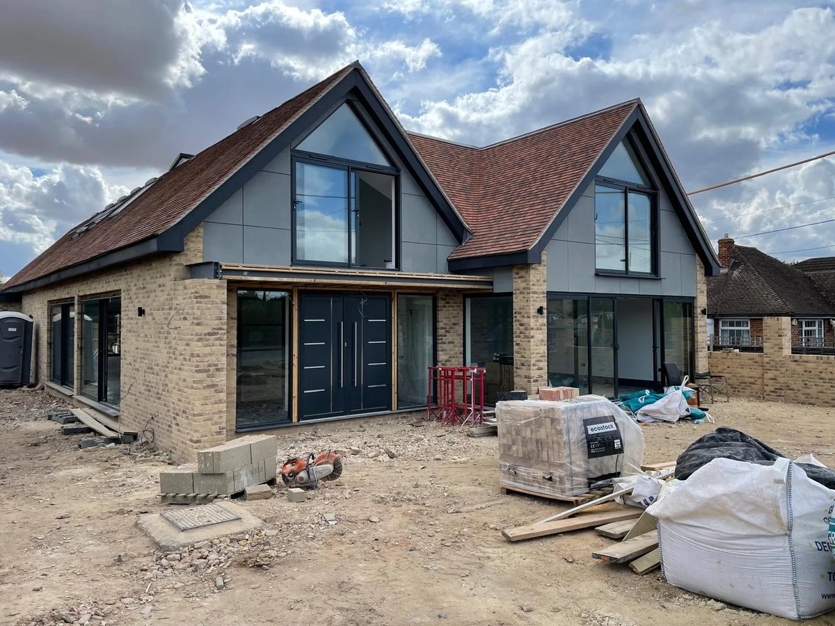 Contemporary new-build home nearing completion with feature glazing and tiled gables