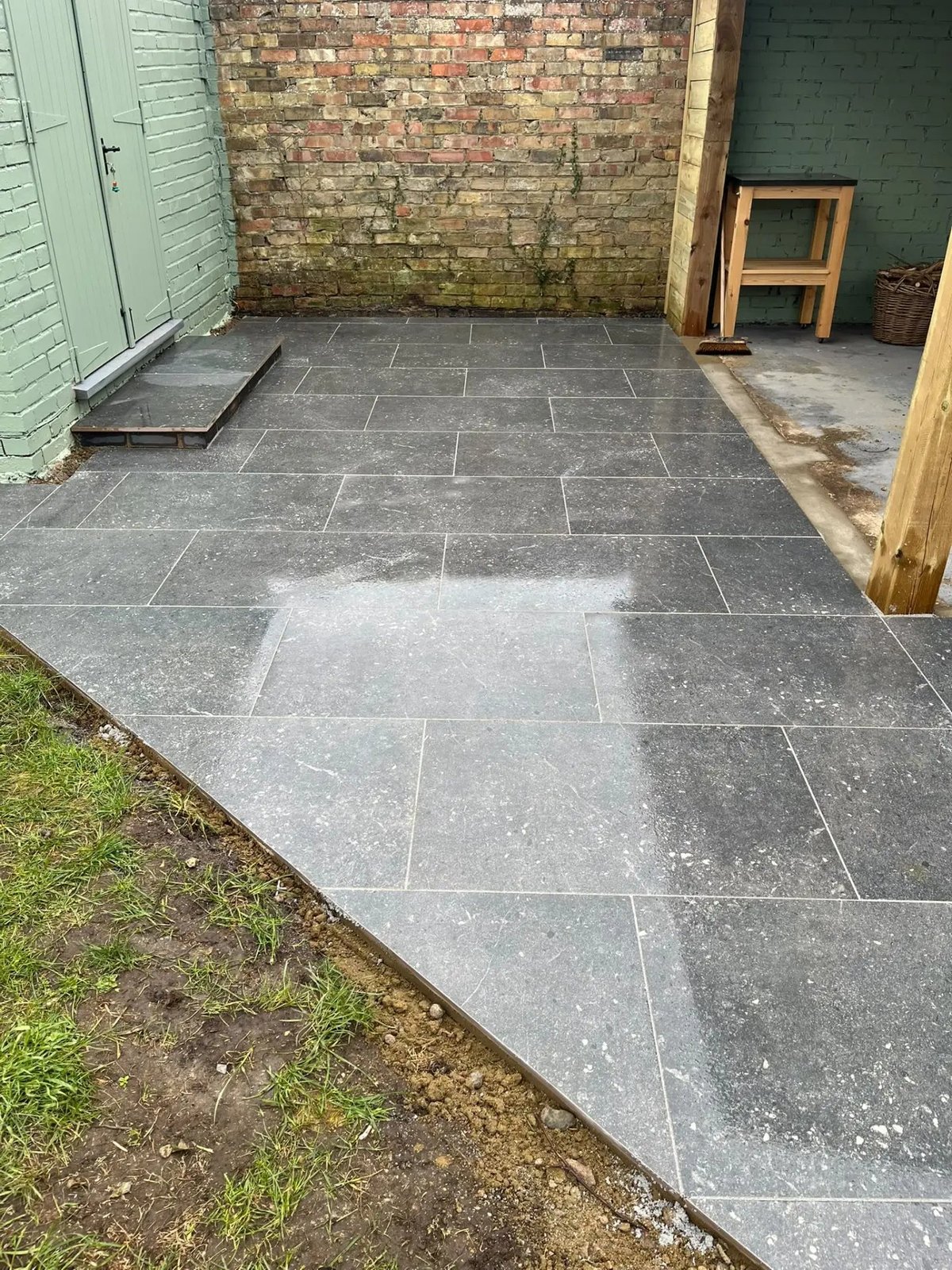Dark porcelain paving laid through to the garden store, Wyton