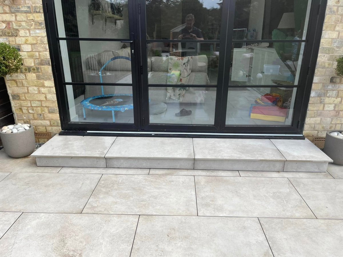 Porcelain slab patio and pathway laid around a garden lawn