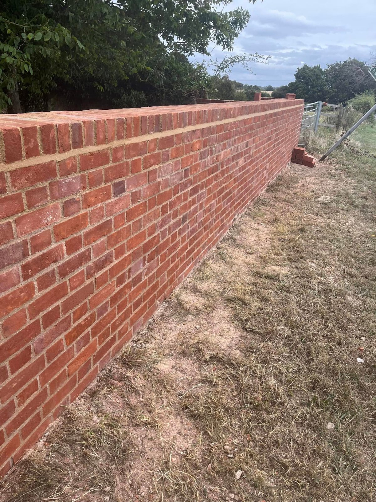Close view of new brickwork garden wall showing consistent coursing and pointing