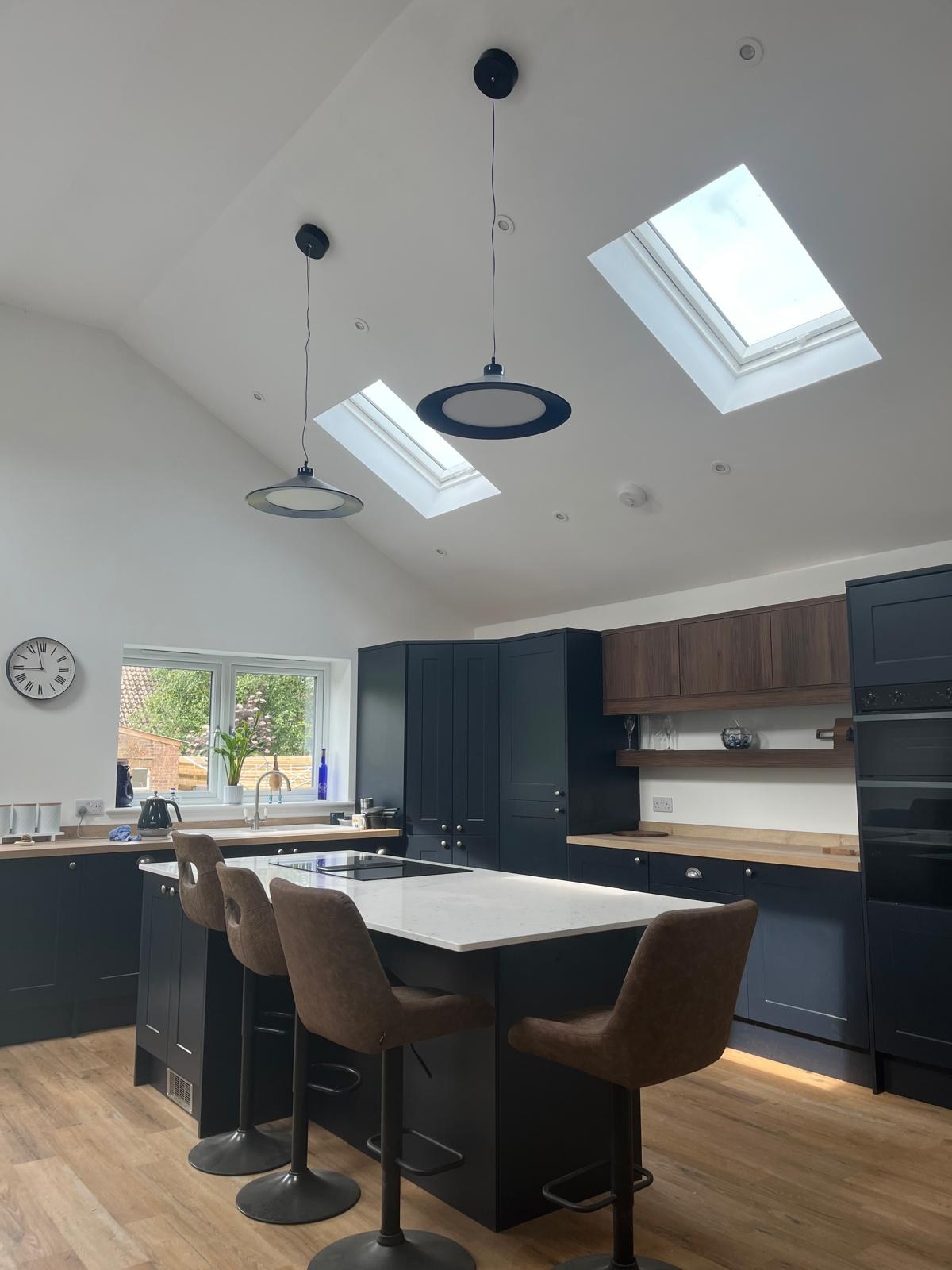Navy shaker kitchen with oak worktops, island seating and vaulted rooflights, Prime Build Services kitchen fitting